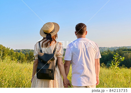 Back view, happy middle aged couple looking to horizon, nature summer background Back view, happy middle aged couple looking to horizon, nature summer background 84213735
