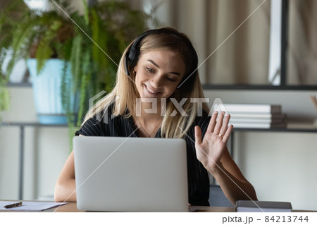 Smiling young blonde businesswoman holding computer video call meeting. Smiling young blonde businesswoman holding computer video call meeting. 84213744