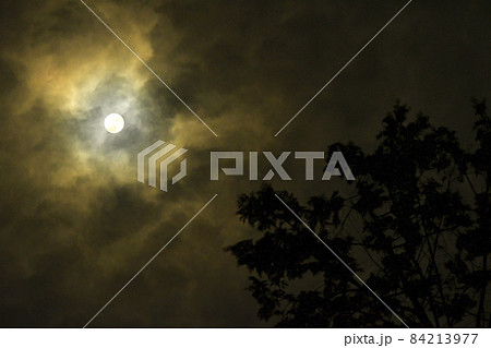 夜空と雲の隙間からのぞく満月 84213977