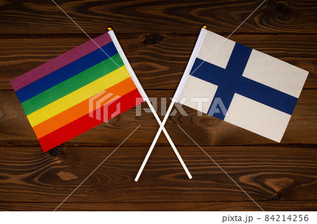 Rainbow flag LGBT and flag of Finland on beautiful brown background with wooden texture. LGBT Pride Month. LGBTQ. LGBTQIA. Human rights concept. Close Up. Top view Rainbow flag LGBT and flag of Finland on beautiful brown background with wooden texture. LGBT Pride Month. LGBTQ. LGBTQIA. Human rights concept. Close Up. Top view 84214256