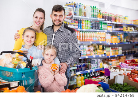 Nice parents with two girls choosing fruits Nice parents with two girls choosing fruits 84214769