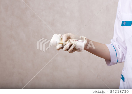 A young woman dressed in a medical uniform keeps money 84218730