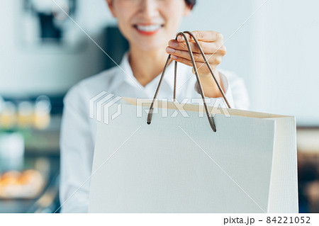紙袋を渡すミドルの店員 84221052