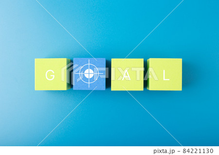 Goal single word and target symbol written on green and yellow geometric figures in a row on blue background Goal single word and target symbol written on green and yellow geometric figures in a row on blue background 84221130