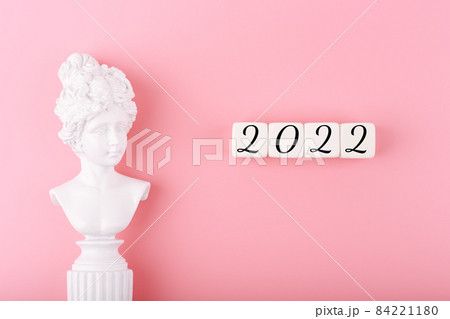Creative trendy 2022 concept. Numbers written on white cubes next to white gypsum woman figure Creative trendy 2022 concept. Numbers written on white cubes next to white gypsum woman figure 84221180