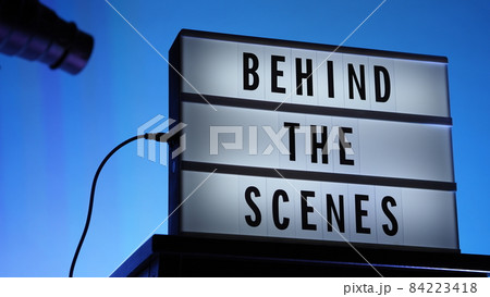 Behind the scenes text on Lightbox or Cinema Light box. Movie board light box on studio stair and light Snoot tripod on colors gradiant Background. Represent behind the scenes team is working on. Behind the scenes text on Lightbox or Cinema Light box. Movie board light box on studio stair and light Snoot tripod on colors gradiant Background. Represent behind the scenes team is working on. 84223418