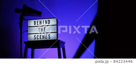 Behind the scenes text on Lightbox or Cinema Light box. Movie board light box on studio stair and light Snoot tripod on colors gradiant Background. Represent behind the scenes team is working on. Behind the scenes text on Lightbox or Cinema Light box. Movie board light box on studio stair and light Snoot tripod on colors gradiant Background. Represent behind the scenes team is working on. 84223446