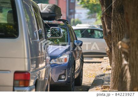 City traffic with cars parked in line on street side. City traffic with cars parked in line on street side. 84223927