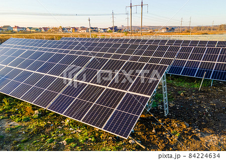 Solar power plant under construction on green field. Assembling of electric panels for producing clean ecologic energy. Solar power plant under construction on green field. Assembling of electric panels for producing clean ecologic energy. 84224634