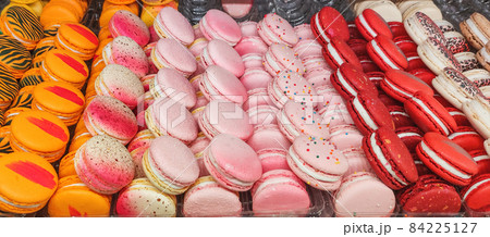 Colorful macaroons. Close-up photo of delicious pastries in box. Differently colored cakes with whipped cream. 84225127