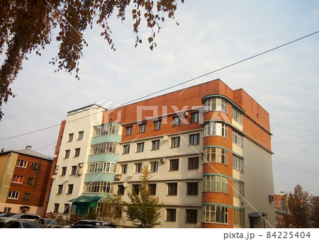 The brown facade of an unusual five-storey house against the background of the autumn sky The brown facade of an unusual five-storey house against the background of the autumn sky 84225404