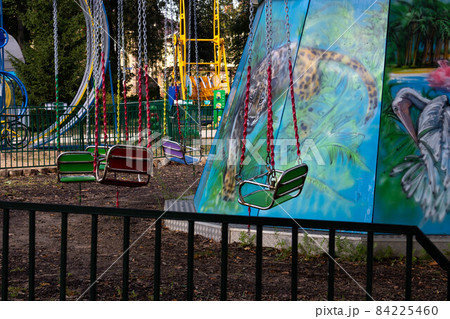 An empty swing with chains on a carousel in a children's park An empty swing with chains on a carousel in a children's park 84225460