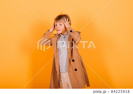 Grimacing emotional redhead fasion boy posing in yellow studio 84225918