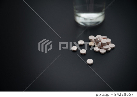 薬物や禁止事項に使えそうなコップと薬の山のイメージ3　俯瞰　コピースペースあり 84228657