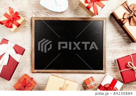 Christmas background with gift boxes on wooden table Christmas background with gift boxes on wooden table 84230884