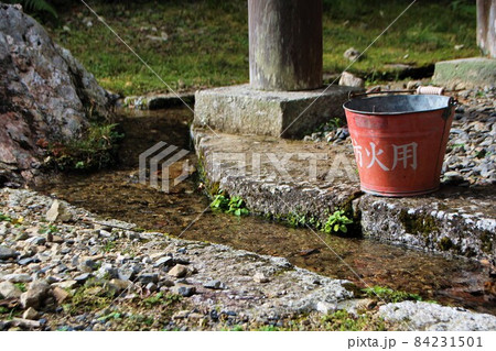 神社の用水路と防火用のバケツ 84231501