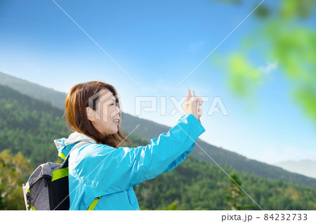 バナーに使いやすい【秋】の登山やトレッキングで自撮りを楽しむ中年の日本人女性 前ボケあり ※秋の紅葉 84232733