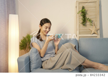 女性　スマホ　リビング　夜 84233342