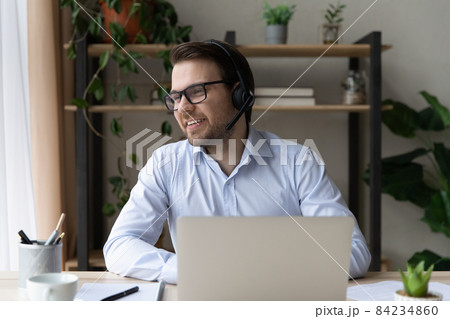 Happy dreamy young businessman holding video call meeting. 84234860