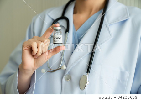 Skillful doctor prepare vaccine proficiently before injection Skillful doctor prepare vaccine proficiently before injection 84235659
