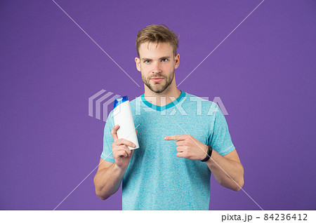 Beauty advice. Man stylish hairstyle holds hair conditioner Beauty advice. Man stylish hairstyle holds hair conditioner 84236412