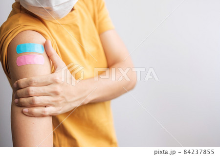woman showing plaster after receiving covid 19 vaccine. Vaccination, herd immunity, side effect, booster dose, vaccine passport and Coronavirus pandemic 84237855