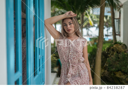 Portrait of attractive caucasian woman with blond long hair wearing casual dress, looks directly at camera. Face expressions concept. 84238287