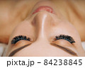 Eyelash Extension Procedure. Woman Eye with Long Eyelashes. Close up, selective focus. 84238845