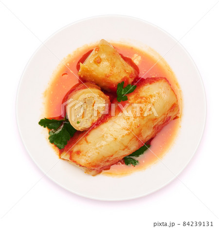Portion of cabbage rolls stuffed with ground beef and rice with sour cream on a plate 84239131