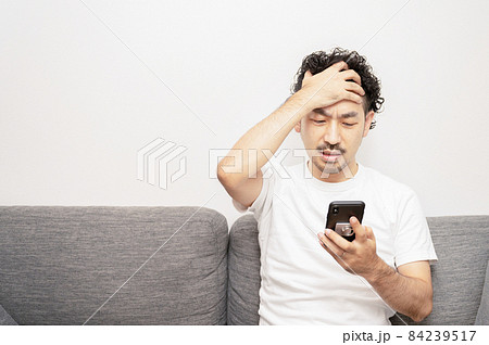 スマホの返事を見て「ヤバイ…」と驚く日本人の中年男性 シャツなし 84239517