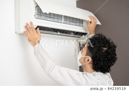 エアコンの掃除をするハウスクリーニング業者さんの後ろ姿 84239519