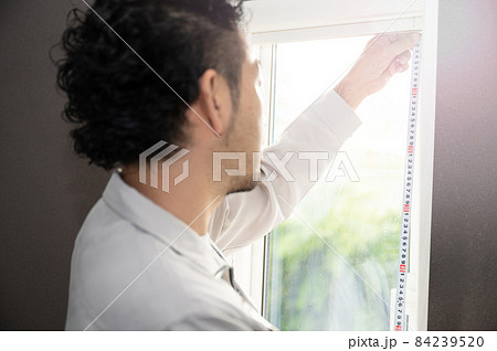 窓枠を計るリフォーム業者のイメージ コピースペースあり 84239520