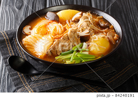 Tasty spicy Gamjatang Korean Pork Bone Soup with creamy potatoes and tender juicy pork bone meat close up in the bowl. Horizontal 84240191