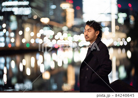 夜景の中でたたずむアジア人(日本人)男性　コピースペースあり 84240645