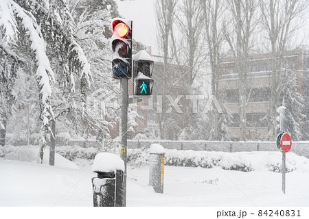 View of city street during heavy snowfall with trapped vehicles 84240831
