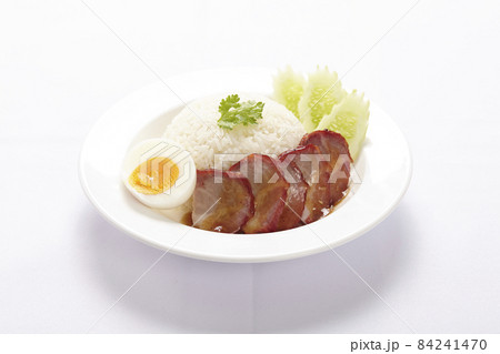 BBQ Pork and Crispy Pork on rice with sauce on white background. 84241470
