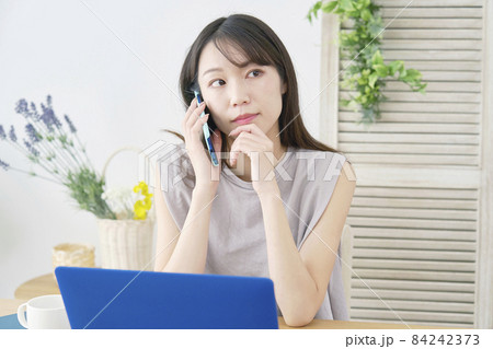 女性 電話する リビング 女性 電話する リビング 84242373