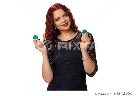 Sexy redheaded woman with a curly hair is posing with some blue chips in her hands. Poker Sexy redheaded woman with a curly hair is posing with some blue chips in her hands. Poker 84242956