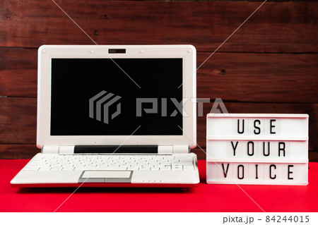 Online voting. Laptop and notepad on a red background. Election concept, place for text. 84244015