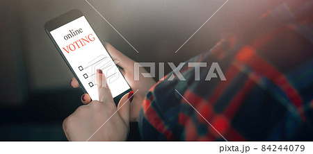 Woman votes online using the phone. Voting and elections concept. Place for text Woman votes online using the phone. Voting and elections concept. Place for text 84244079
