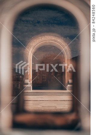 Carved wooden door to the cathedral. Photo through the window. Interesting idea of the photographer Carved wooden door to the cathedral. Photo through the window. Interesting idea of the photographer 84248560