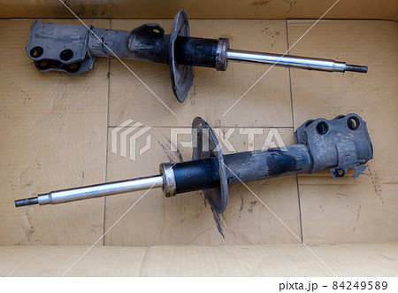 The old shock absorber in the crate box that was removed from a small sedan after being inspected. 84249589