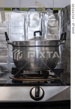 The large metal pot on the gas stove after cooking in the kitchen. 84249590