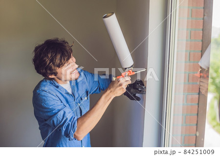 Man in a blue shirt does window installation 84251009