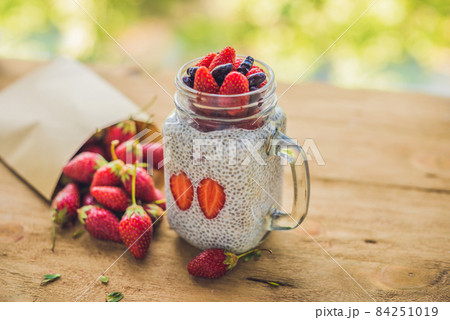 Healthy layered dessert with chia pudding, strawberry and honeysuckle in a mason jar on rustic background Healthy layered dessert with chia pudding, strawberry and honeysuckle in a mason jar on rustic background 84251019
