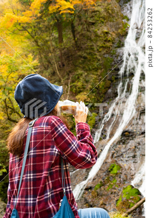 紅葉の滝を見て休憩するミドル女性 84253262