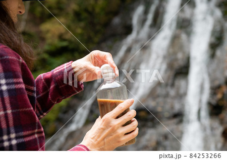 紅葉の滝を見て休憩するミドル女性 84253266