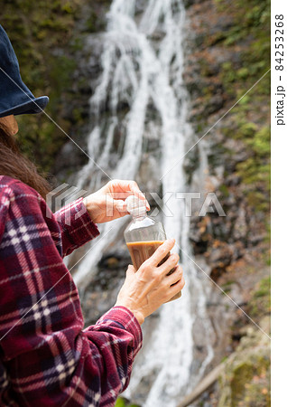 紅葉の滝を見て休憩するミドル女性 84253268