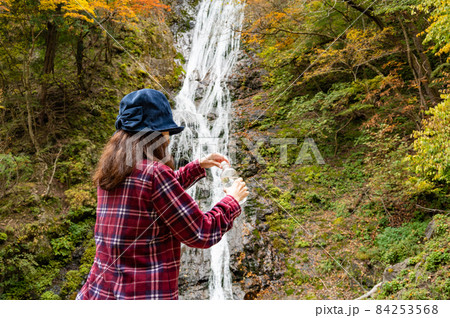 紅葉の滝で休憩するミドル女性 84253568