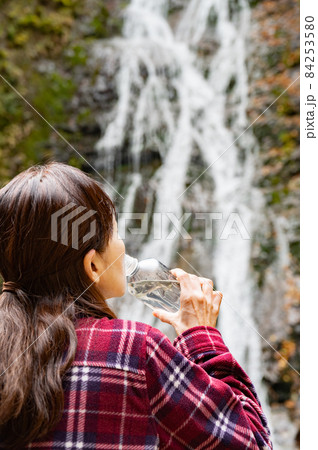 紅葉の滝で休憩するミドル女性 84253580